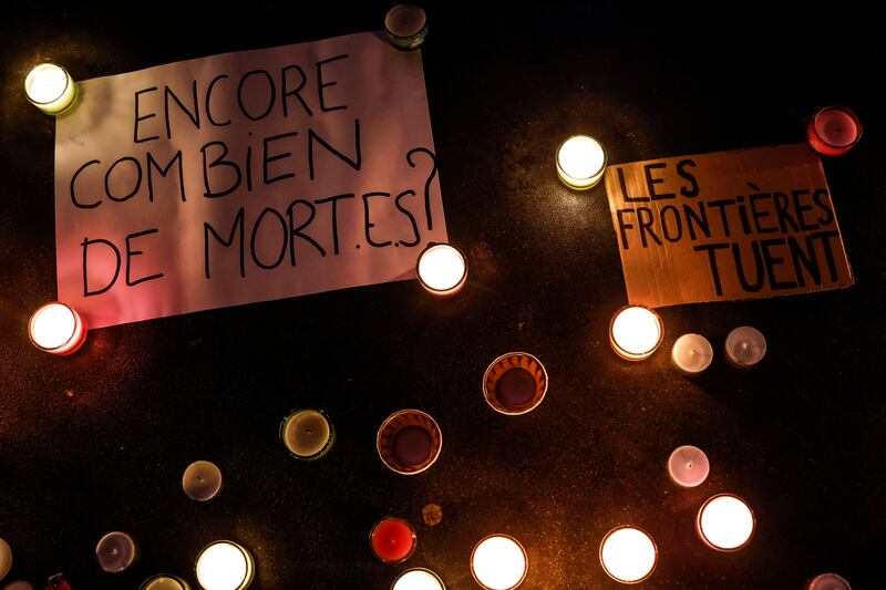 Messages reading 'How many more deaths' and 'borders kill' are illuminated by candlelight during a Paris demonstration in support of migrants. Photo: EPA