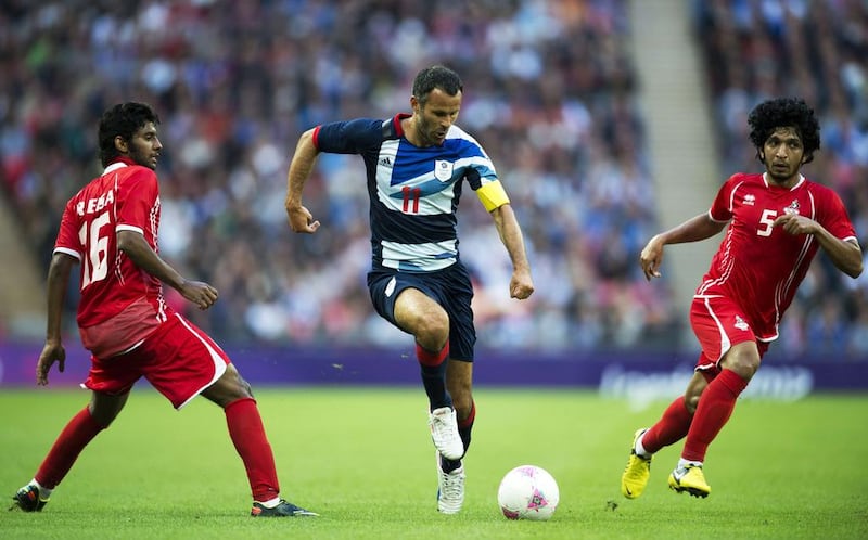 Ryan Giggs runs between Eisa Rashed (L) and Amer Abdulrahman during the London 2012 Olympic Games men's football match between Britain and the UAE at Wembley Stadium in London. AFP