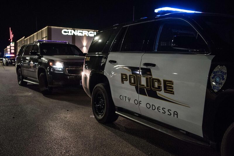 Police cars and tape block off a crime scene where a gunman was shot and killed at Cinergy Odessa movie theater in Midland, Texas. Officials say the unidentified suspect killed 5 people and injured 21 in Midland and nearby Odessa.  AFP