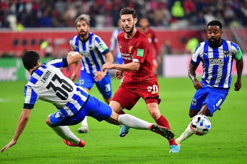 Liverpool's English midfielder Adam Lallana (C) passes the ball as he is marked by Monterrey's defender Stefan Medina during the 2019 FIFA Club World Cup semi-final football match between Mexico's Monterrey and England's Liverpool at the Khalifa International Stadium in the Qatari capital Doha on December 18, 2019.  / AFP / Giuseppe CACACE
