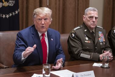U.S. President Donald Trump speaks to members of the media, as Mark Milley, chairman of the joint chiefs of staff, right, listens during a briefing with senior military leaders in Washington, D.C., U.S., on Monday, Oct. 7, 2019. Trump appeared to backpedal after giving Turkey a green light to attack U.S.-allied Kurdish forces in northern Syria, warning Ankara in a tweet that he would "totally destroy and obliterate" the country's economy if it takes unspecified "off limits" actions. Photographer: Ron Sachs/CNP/Bloomberg