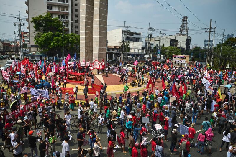 Filipino workers and activists with masks and shields march on the streets in the nation's capital Manila to celebrate May Day on Saturday. Getty Images