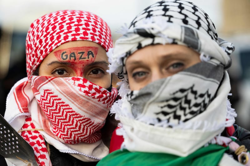 Two pro-Palestinian protestors pose outside the Hilton Hotel in Philadelphia, Pennsylvania, where US President Joe Biden was attended a fundraiser on December 11, 2023. AFP