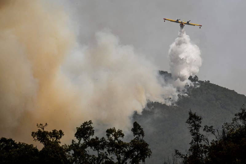 An amphibious aircraft drops water over the fire in Reguengo. AFP