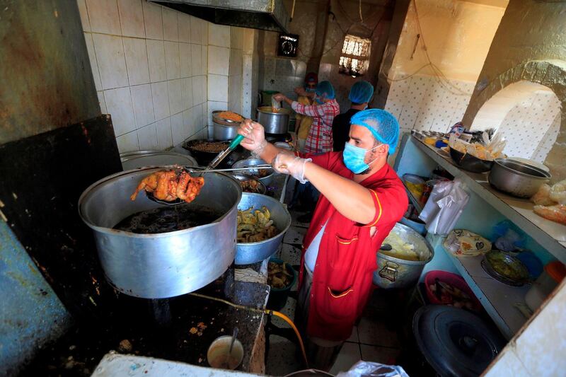 Cooks wearing protective masks as a measure against COVID-19 coronavirus disease prepare food in a restaurant kitchen in Yemen. AFP