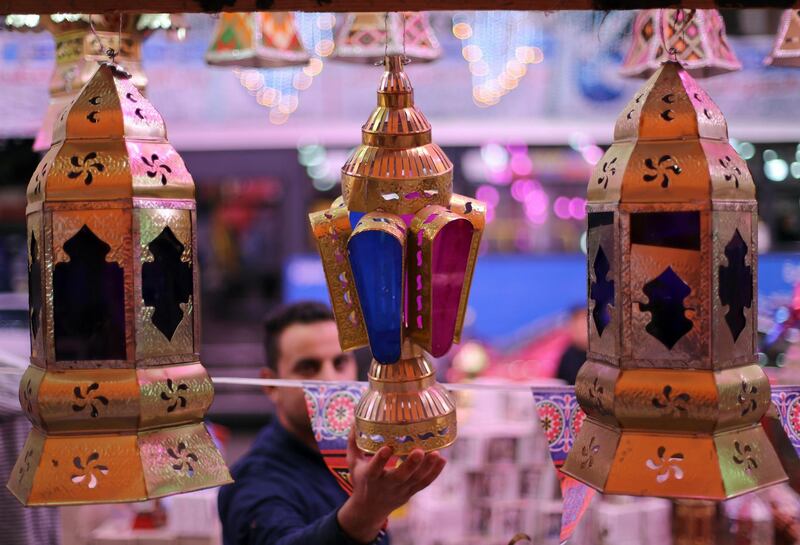 A man checks a traditional Ramadan lantern called "fanous" at a shop stall in Cairo, Egypt. Reuters