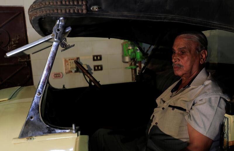 Sayed Sima sits in a 120-year-old American 1900 Auburn automobile in his store. Reuters