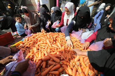 People buy carrots at a local market in Niklah village, Giza, Egypt. The central bank said the rate increase is aimed at lowering inflation. EPA 