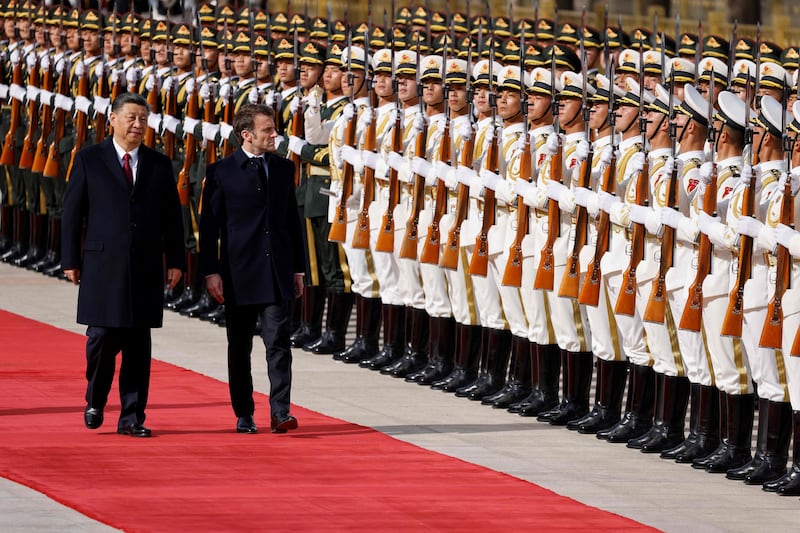 Mr Xi and Mr Macron review an honour guard at the official welcoming ceremony in Beijing. AFP