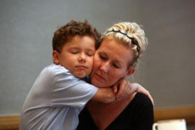 Marnie Pearce, 40, holds her son Laith, 7, before turning herself into Dubai Courts.