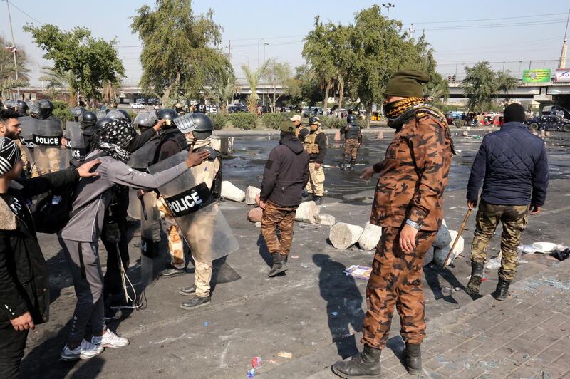 Iraqi protesters speak with anti-riot policmen during a strike amd anti-government protets in central Baghdad.  EPA