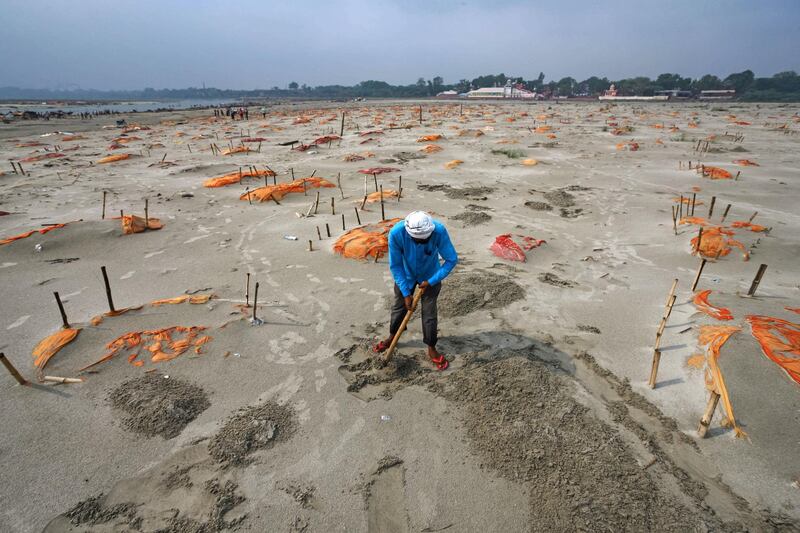 Bodies, some of which are believed to be Covid-19 victims, are seen partially exposed in shallow sand graves after rains washed away the top layer of sand at a cremation ground on the banks of the Ganges River in Shringverpur, north-west of Allahabad, Uttar Pradesh. Getty Images