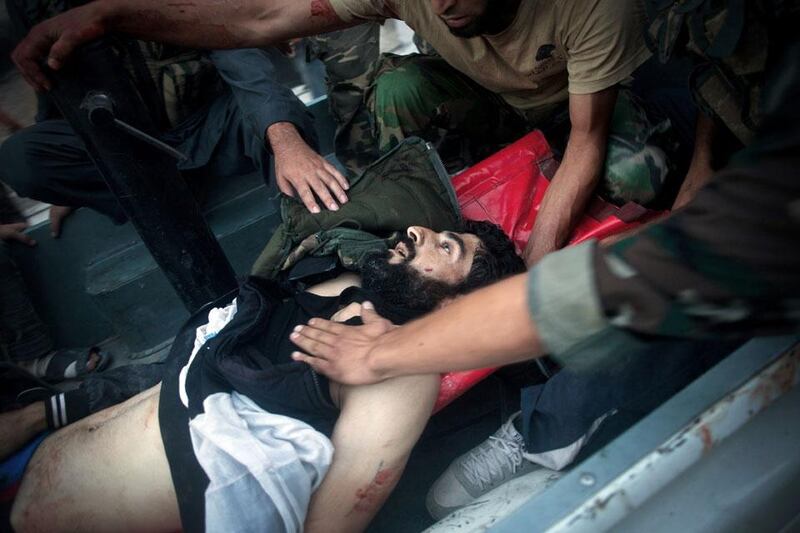 FSA soldiers help transport a severely wounded colleague after being shot by a Syrian Army sniper in Izaa district. Manu Brabo / AP Photo