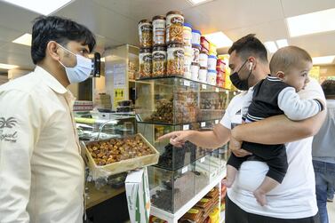 Bilal Ajawi takes his newborn son Jad, six-months-old, first time date shopping this Ramadan, at Royal Dates in the Mina market. Khushnum Bhandari for The National