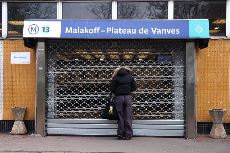 A commuter outside a closed metro station in Paris. EPA