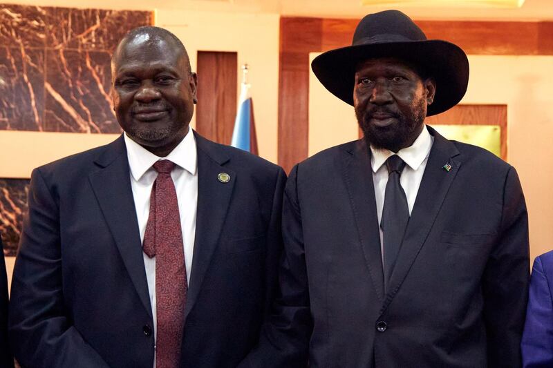 South Sudanese President Salva Kiir stands with First Vice President Riek Machar as they attend a swearing-in ceremony at the State House in Juba, on February 22, 2020. AFP
