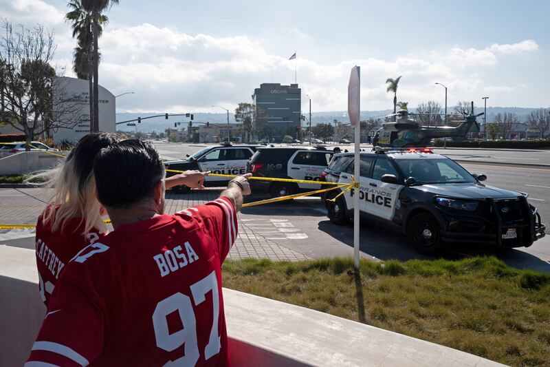 Art Benitez and his son Ethan watch as police use armored vehicles to surround a white cargo van, believed by law enforcement to be connected to the Monterey Park mass shooting. Reuters