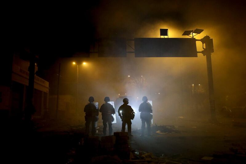 Soldiers stand on a street by El Arbolito park during a military curfew in Quito, Ecuador.  AP