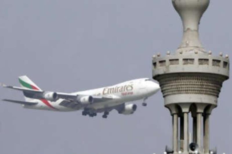 An Emirates Airlines' airplane flies past a minaret 29 December 2006 in the emirate of Dubai. The company vice chairman said he believes that the airline will have too little rather than too much capacity even after its 121 billion Dirhams spent -although the airbus A380 will arrive at Emirates hangars two years late, the airline is optimistic about its expansion plans for 2007. AFP PHOTO/KARIM SAHIB