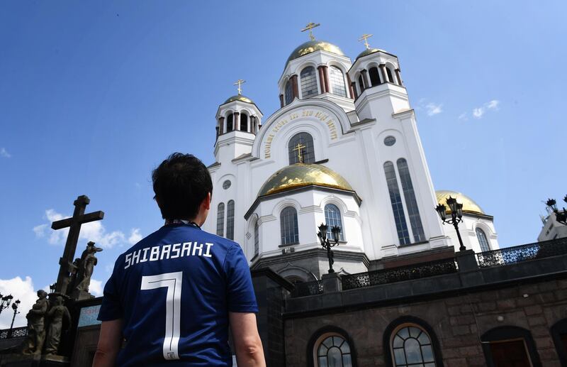 A Japanese fan looks at the Cathedral on the Blood of Alls Saints in Ekaterinburg, Russia. Anne-Christine Poujoulat / AFP