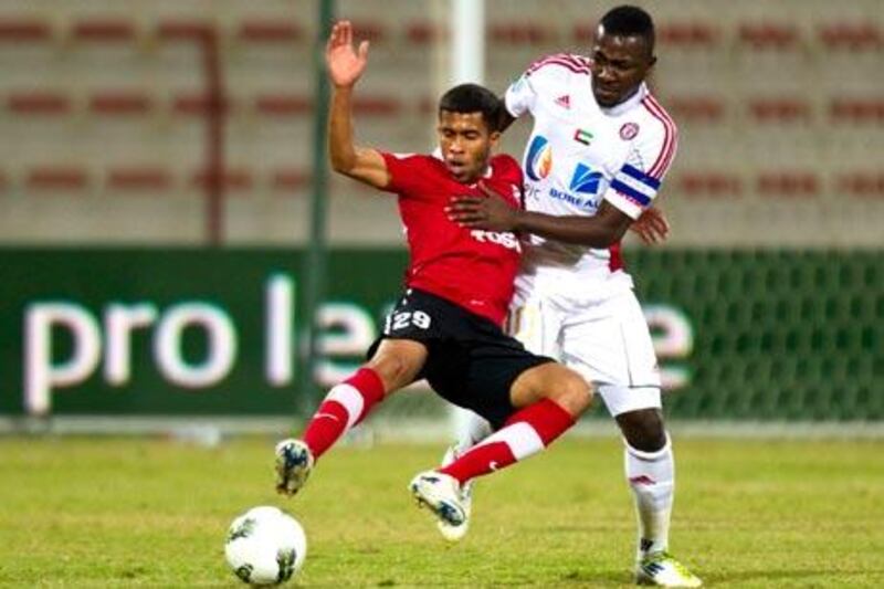 Al Jazira’s Diaky Ibrahim, right, is tackled by Al Ahli’s Ali Hussain in last weekend’s Pro League match. Tonight Jazira face Al Ain in the Etisalat Cup and a win could give them early qualification to the semis.