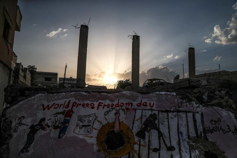 epa06715388 The sun sets over a new graffiti by Azeez al-Asmer, Binnish Town, Idlib, Northern Syria, 05 May 2018 (Issued 06 May 2018). Azeez al-Asmer, a 45-years-old Syrian graffiti artist who paints graffiti and murals on the walls of the town of Binnish in northern Syria since 2013. His work is usually sarcastic and reflects on events regarding the Syrian conflict.  EPA/MOHAMMED BADRA