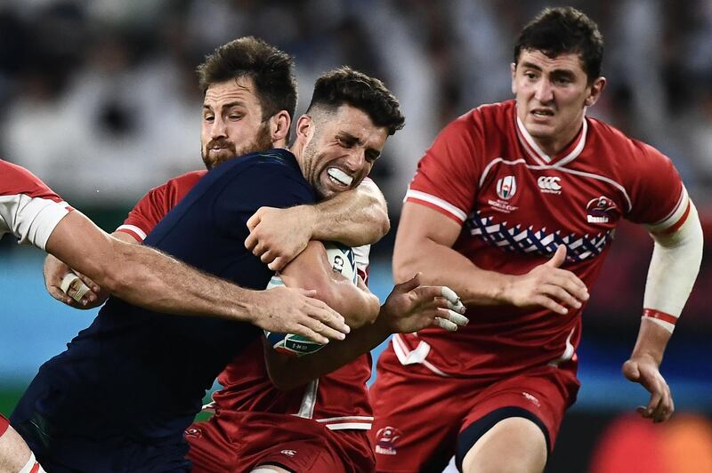 Scotland's fly-half Adam Hastings (C)  is tackled by Russia's flanker Vitaly Zhivatov (L)  during the Japan 2019 Rugby World Cup Pool A match between Scotland and Russia at the Shizuoka Stadium Ecopa in Shizuoka. AFP