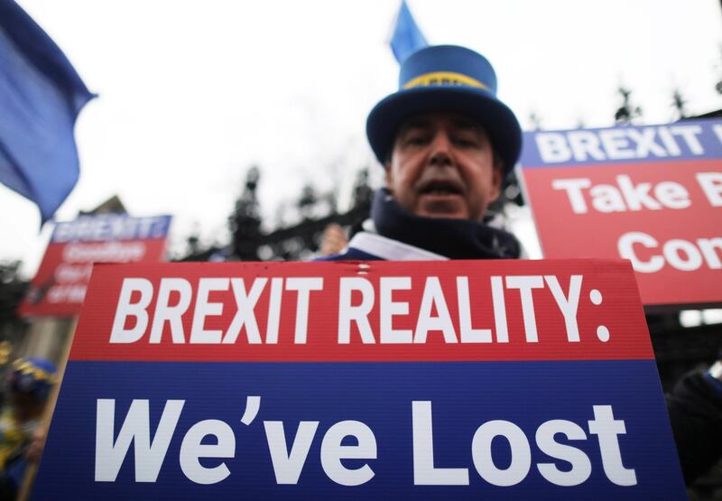 An anti-Brexit protester holding a banner demonstrates outside the Houses of Parliament in London, Britain. Reuters