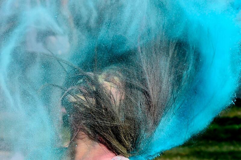 A student from Lalbhai Dalpatbhai (LD) College of Engineering shakes her head covered with coloured powder as she celebrates with others 'Holi', the Hindu spring festival, with eco-friendly coloured powders in Ahmedabad on March 7, 2020. Holi, the popular Hindu spring festival of colours is observed in India and across countries at the end of the winter season on the last full moon of the lunar month. AFP