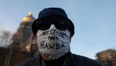 A man wears a protective face mask as he attends a solidarity event for Mawda Shawri at the courthouse in Brussels, Monday, Nov. 23, 2020. A trial opened on Monday in the shooting death of two-year old toddler, Mawda Shawri, who was in a van during a high-speed chase between police and suspected migrant smugglers seeking to get to Britain. At the trial in Belgium's southern Mons, a policeman stands accused of involuntary manslaughter and two other men for being suspected migrant smugglers. (AP Photo/Virginia Mayo)