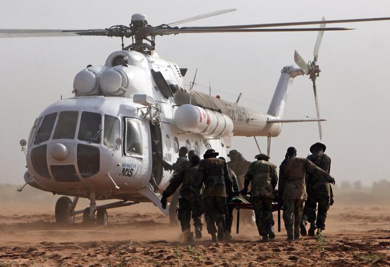 A handout picture from the African Union Mission in the Sudan (AMIS) shows AMIS soldiers carrying an injured colleague to an helicopter at Haskanita military group site (MGS) 30 September 2007 following an attack. The African Union began 01 October 2007 probing the unprecedented attack on one of its bases in Sudan's war-ravaged Darfur that left 10 peacekeepers dead and 25 missing, vowing to punish those responsible. The attack by a large, organised group of heavily armed men who overran southern Darfur's Haskanita camp in 30 vehicles took place 29 September night, the worst assault on the under-manned force since it deployed in July 2004. AFP PHOTO/HO/AMIS/STUART PRICE (Photo by STUART PRICE / AMIS / AFP)