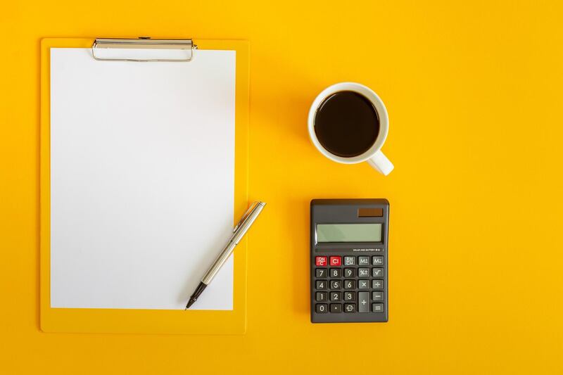 Clipboard and Calculator on Yellow Background. Getty Images