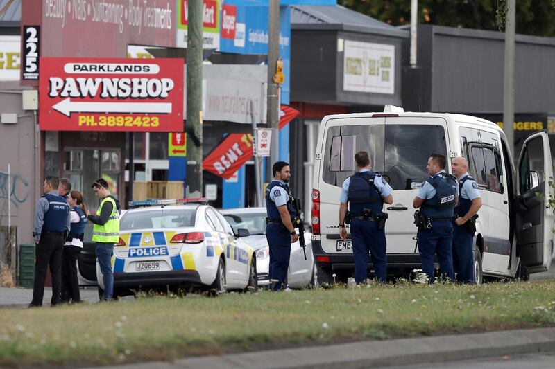 FILE - In this March 15, 2019, file photo, police stand outside a mosque in Linwood, Christchurch, New Zealand. Some New Zealand gun owners are upset they're being compelled to hand over their assault weapons for money. Others believe a government-imposed ban on certain semi-automatics following the March massacre is the best way to combat gun violence. New Zealand is six weeks into an ambitious program to buy tens of thousands of guns from owners across the country. After a gunman killed 51 people at two Christchurch mosques, the government rushed through new laws banning military-style semi-automatics. (AP Photo/Mark Baker, File)