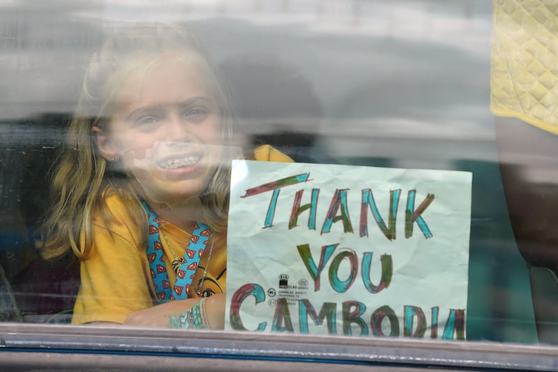 A young passenger from Westerdam cruise ship holds up a sign on a bus after disembarking in Sihanoukville. AFP