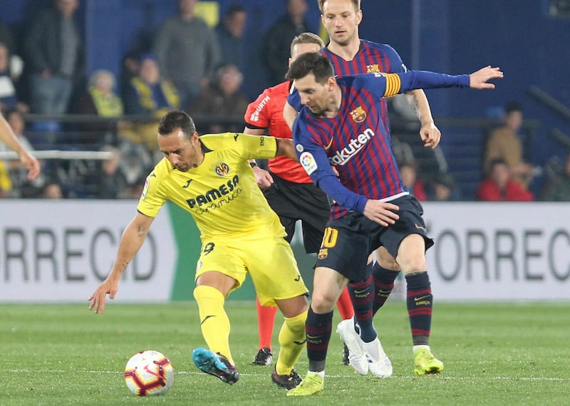Barcelona's Lionel Messi vies for the ball with Villarreal's Santi Cazorla. AP Photo