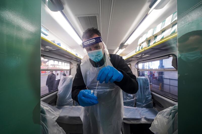 BRIGHTON, ENGLAND - MARCH 19: Railway staff carry out lateral flow covid tests on colleagues in a temporary testing facility on a converted train parked on platform eight of Brighton railway station on March 19, 2021 in Brighton, England. Govia Thameslink Railway have set up a Covid-19 testing centre for railway staff operating from a Southern Railway train carriage at Brighton Station's platform eight. Staff from Southern, Thameslink, Great Northern and Gatwick Express can get twice-weekly lateral flow tests giving results within half an hour. (Photo by Chris Eades/Getty Images)