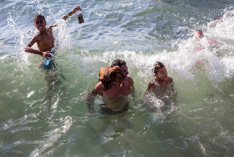 A man balances his dog on his shoulder as he takes a dip in Havana, Cuba. Desmond Boylan/AP Photo