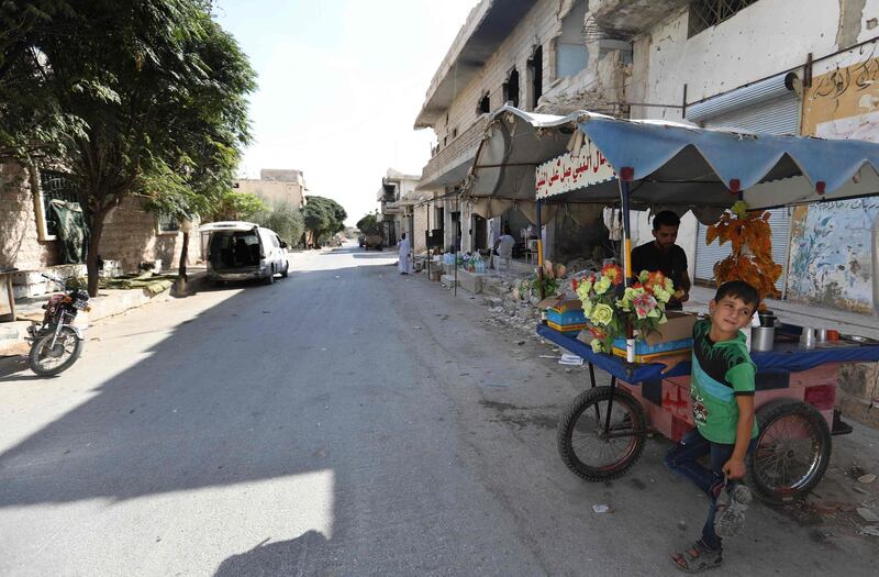 A Syrian man and a child sell drinks in an empty street in Morek, a town in the northern countryside of Hama province. AFP