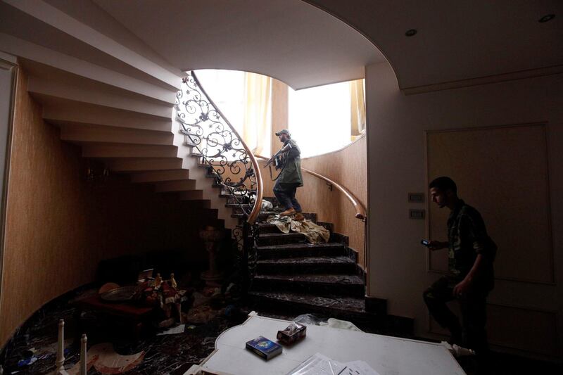 Anti-Gaddafi fighters walk up the stairway in a house belonging to one of Muammar Gaddafi's family members in the city of Sirte October 19, 2011. REUTERS/Saad Shalash  (LIBYA - Tags: POLITICS CIVIL UNREST) *** Local Caption ***  SS502_LIBYA_1019_11.JPG