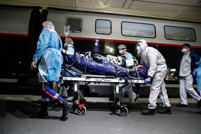 Medical staff transfer a patient infected with the coronavirus to a train at the Gare d'Austerlitz train station in Paris. Pool via AP