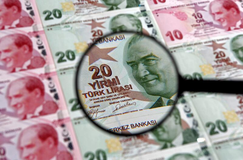 FILE PHOTO: A 20 lira banknote is seen through a magnifying lens in this illustration picture taken in Istanbul January 28, 2014. Turkey's central bank governor raises hopes of emergency rate hike in face of opposition from Prime Minister Tayyip Erdogan, denying he is hostage to political pressures and vowing to fight rising inflation and tumbling lira. REUTERS/Murad Sezer/File Photo