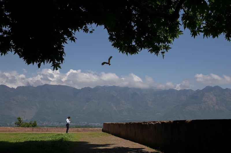 A Kashmiri Muslim checks his cell phone after praying outside a closed Muslim shrine in Srinagar. AP Photo