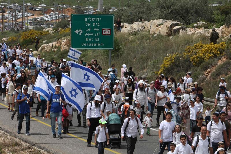 Israeli settlers march towards the outpost of Evyatar in the occupied West Bank on Monday. AFP
