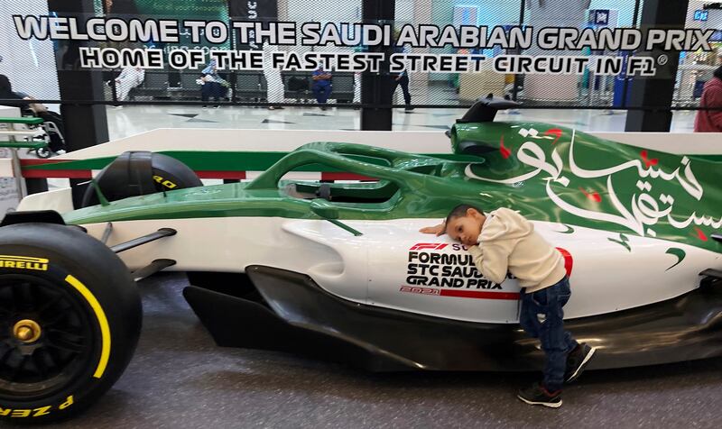 A boy hugs a race car promoting the Formula One, at the King Abdulaziz International Airport in Jiddah, Saudi Arabia. Next month's F1 race will be the first time Saudi Arabia hosts the premier sporting event, though the kingdom has hosted the lesser known Formula-E race in past years in an effort to raise the country's profile as a tourist destination. AP Photo