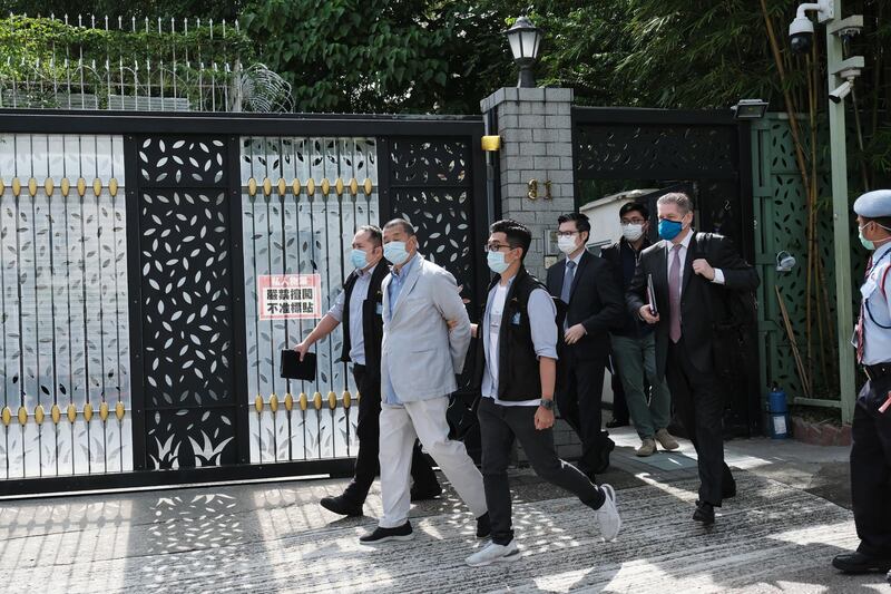 Jimmy Lai, chairman of Next Digital Ltd., second left, is led away from his residence by law enforcement officials in Hong Kong, China, on Monday, Aug. 10, 2020. Hong Kong police arrested media tycoon and prominent democracy activist Jimmy Lai under a national security law passed in late June for allegedly colluding with foreign forces. Photographer: Paul Yeung/Bloomberg