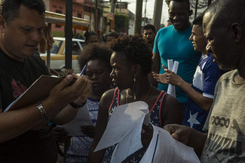 Migrants from Haiti wait in line next to the Mexican Commission for Migrant Assistance office to get the documents needed that allows them to stay in Mexico, in Tapachula, early Thursday, June 20, 2019. The flow of migrants into southern Mexico has seemed to slow in recent days as more soldiers, marines, federal police, many as part of Mexico's newly formed National Guard, deploy to the border under a tougher new policy adopted at a time of increased pressure from the Trump administration.  (AP Photo/Oliver de Ros)