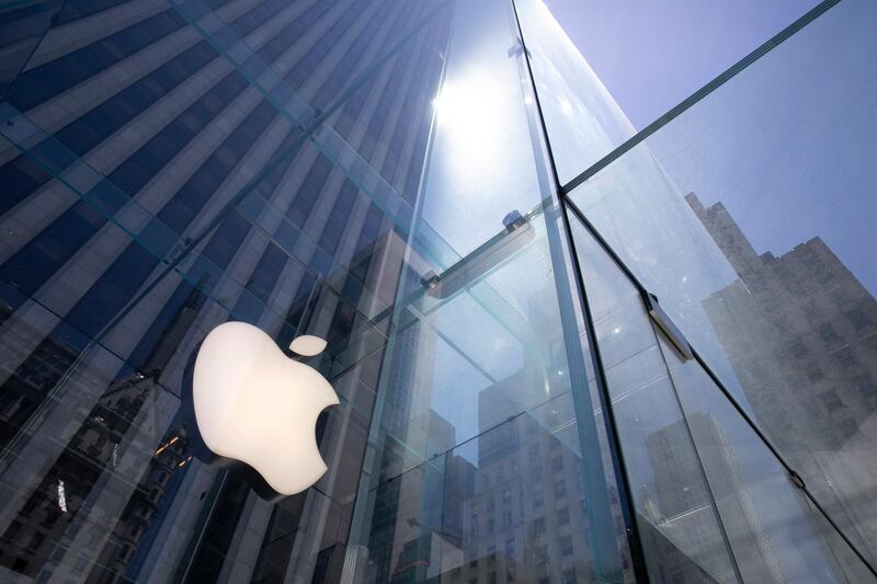 FILE - In this June 16, 2020, file photo, the sun is reflected on Apple's Fifth Avenue store in New York. Apple will cut its app store fee in half from 30% to 15% for most developers beginning Jan. 1, the biggest change in its commission rate since the app store began in 2008. The fee reduction will apply to developers who made up to $1 million from the app store in 2020, which is the â€œvast majorityâ€ of developers in the store, Apple said. (AP Photo/Mark Lennihan, File)