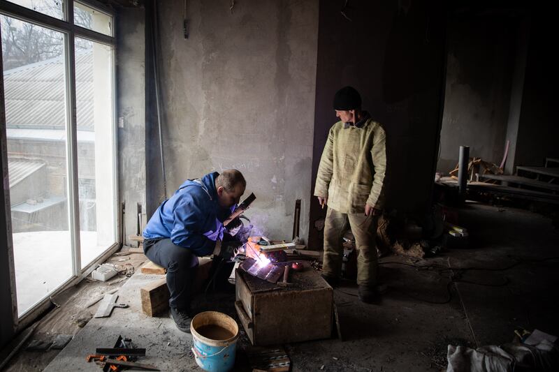 Bogdan Shur and his colleague weld scrap steel together to make the armoured garments in Mykolaiv, Ukraine.