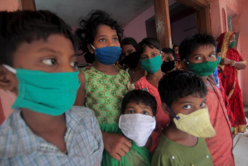 Children wearing masks as a precaution against the spread of coronavirus stand at a relief camp at Paradeep, on the Bay of Bengal coast in Orissa, India. AP