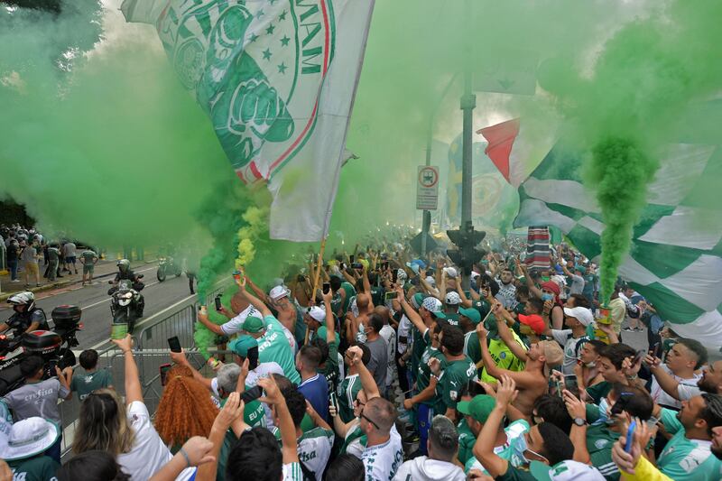 Supporters of Palmeiras watch a bus transporting its players pass by on its way from the club's training centre to the airport, from where they will fly to Abu Dhabi to play in the FIFA Club World Cup, in Sao Paulo, Brazil, on February 2, 2022.  (Photo by NELSON ALMEIDA  /  AFP)